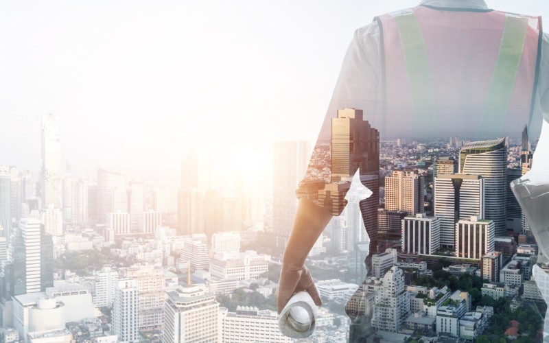 Foto de um engenheiro de frente para uma cidade